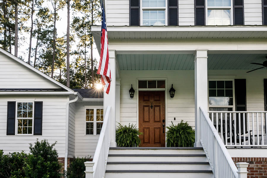Personal Insurance - Modern White Farmhouse with a Proud American Flag Out Front
